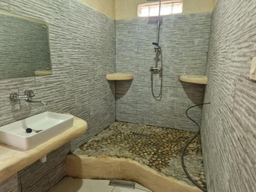 a bathroom with a sink and a shower with a sink at LE KABOSS in Toliara