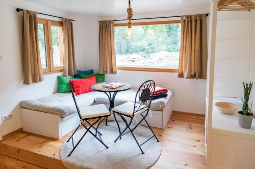 a living room with a table and chairs and a couch at WOHNWAGON Tiny Houses I in Gutenstein