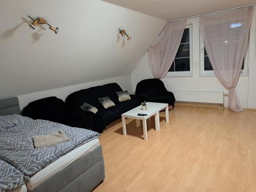 a living room with a black couch and a table at Apartmán Chiarita in Nemšová