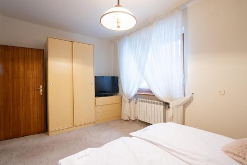 a bedroom with a bed and a window with a television at Apartamenty w Gorcach in Nowy Targ