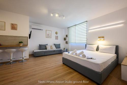 a bedroom with a king sized bed and a couch at Nesto Athens Airport Zen in Spáta