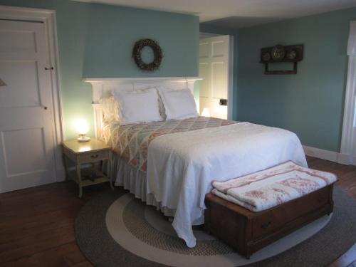a bedroom with a bed and a table with a lamp at Grand Oak Manor Bed and Breakfast in Granville Ferry