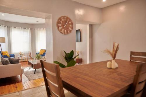 a dining room with a table and a clock on the wall at Cozy apartment 1st 10min Walk Downtown and City View in Providence