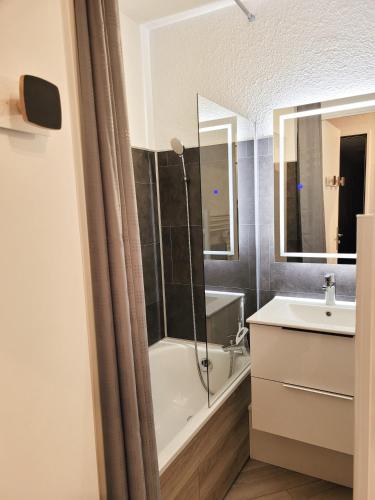 une salle de bain avec une baignoire, un lavabo et une douche dans l'établissement Isola 2000 pied des pistes-wifi, à Isola