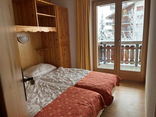 - une chambre avec un lit et une fenêtre avec un balcon dans l'établissement Pracondu OUTDOOR & FUN appartement 2 chambres avec Balcon, à Nendaz