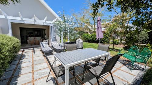 a patio with a table and chairs in a yard at Kingswood Close in George