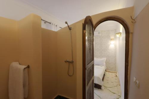 ein Bad mit Dusche und eine Tür zu einem Schlafzimmer in der Unterkunft Riad Jenan L'mouassine in Marrakesch