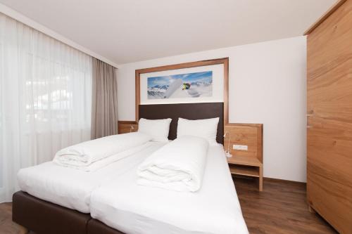 a bedroom with a large bed with white sheets at Stöcklhof in Pettneu am Arlberg