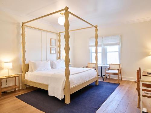 a bedroom with a four poster bed and a desk at The Lake House on Canandaigua in Canandaigua