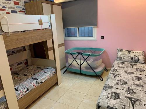 a bedroom with two bunk beds and a table at Petite Villa de 160m2 à Mohammedia in Mohammedia