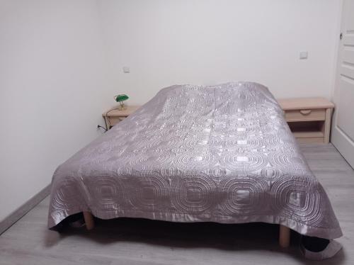 uma cama com um edredão de prata num quarto em Résidence naturiste Eden 117 em Leucate
