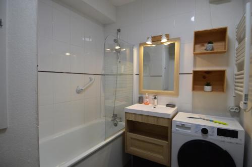 uma casa de banho com um chuveiro, um lavatório e uma máquina de lavar roupa em Le Cocon de Nacre - à 300m de la plage - wifi em Courseulles-sur-Mer