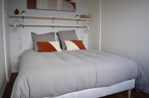 - une chambre avec un lit blanc et des oreillers dans l'établissement Le Cocon de Nacre - à 300m de la plage - wifi, à Courseulles-sur-Mer