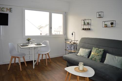 un salon avec un canapé et une table dans l'établissement Le Cocon de Nacre - à 300m de la plage - wifi, à Courseulles-sur-Mer