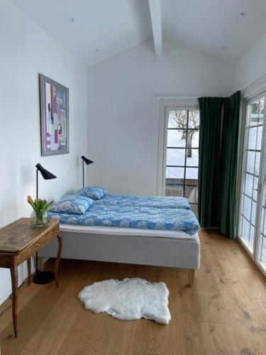 1 dormitorio con cama, mesa y ventana en Gisebo Vingård, en Huskvarna