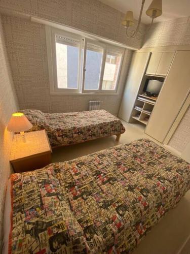Habitación de hotel con 2 camas y TV en Departamento 3 ambientes vista al mar en Playa Grande con cochera cubierta en Mar del Plata