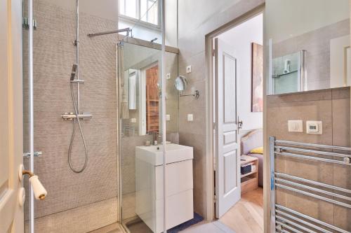 une salle de bain avec douche et lavabo dans l'établissement Appartement de standing 4 étoiles sur l'île Saint-Louis by Weekome, à Paris