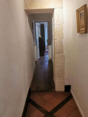 een hal die leidt naar een kamer met witte muren en tegelvloeren bij Alice & Jeanne - Chambre d'hôte in Lectoure