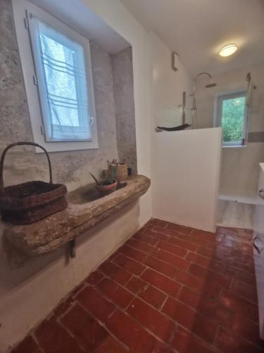 een badkamer met een stenen wastafel en een raam bij Alice & Jeanne - Chambre d'hôte in Lectoure