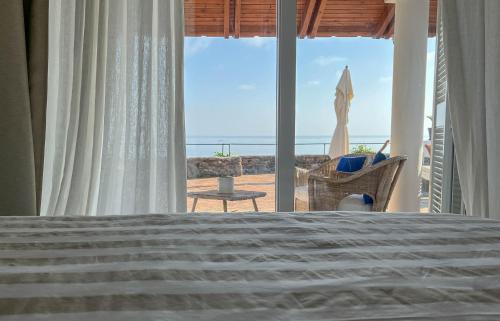 a bedroom with a bed and a view of the beach at Nelinda Waterfront Accommodation in Ischia