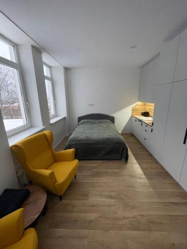 una camera con letto e sedia gialla di Airport lux apartment 30 Self Check-In Free Parking a Vilnius