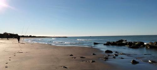 einen Strand mit Felsen und dem Meer an einem sonnigen Tag in der Unterkunft Casa Altomare in Ladispoli