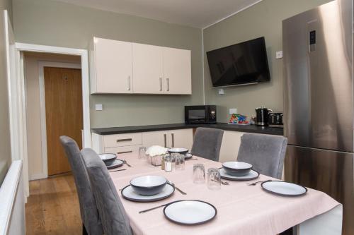 Il comprend une cuisine équipée d'une table, de chaises et d'un réfrigérateur. dans l'établissement Market Square Apartments, à Huddersfield