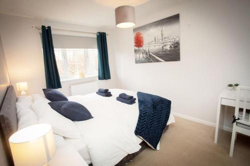 ein Wohnzimmer mit einem weißen Sofa und einem Bett in der Unterkunft Wigmore Lodge - FREE Parking & Airport & M1 & Contractor & Leisure in Luton