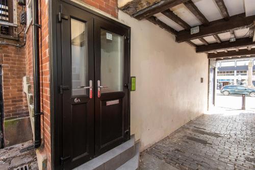 une porte noire sur le côté d'un bâtiment dans l'établissement Market Square Apartments, à Huddersfield