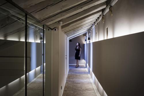 a woman walking down a hallway in a building at Seven Historical Suites in Trieste