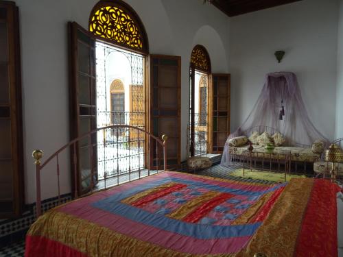 een slaapkamer met een groot bed en een tapijt op de vloer bij Dar Al Safadi in Fès