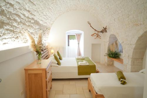 a bedroom with two beds and a window in a room at Antiche Dimore TerraRossa in Alberobello