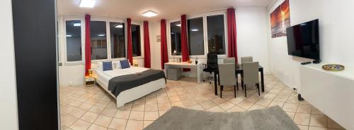 1 dormitorio con cama, mesa y TV en Lux Apartment near Frankfurt!, en Mörfelden-Walldorf