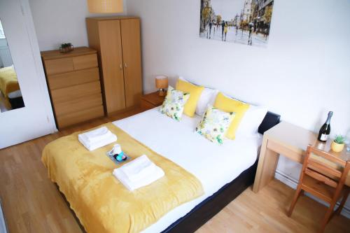 a bedroom with a large white bed with yellow sheets at Lovely 2-Bed Apartment in Harrow in Harrow