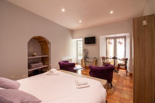 サルラ・ラ・カネダにあるL'Appartement du "Coup de Coeur de Sarlat"のベッドルーム1室(ベッド2台、テーブル、椅子付)