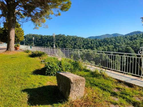 a stone bench sitting in the grass next to a fence at Villa Montgrau in Llano de Gorra