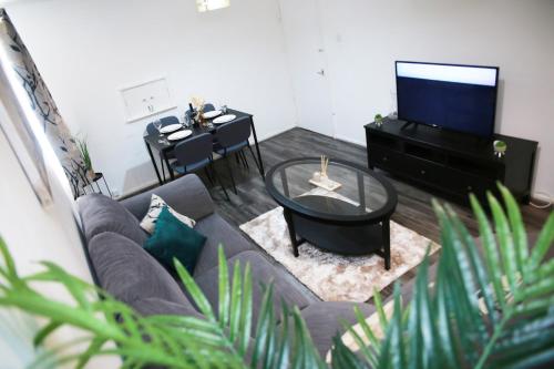 a living room with a couch and a tv and a table at Lovely 2-Bed Apartment in Harrow in Harrow