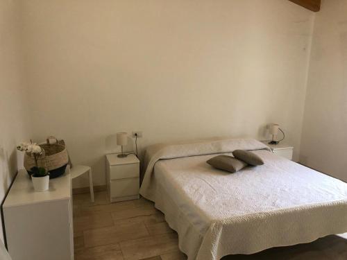 ブドーニにあるTrilocale con terrazzaの白いベッドルーム(ベッド1台、ナイトスタンド2台付)
