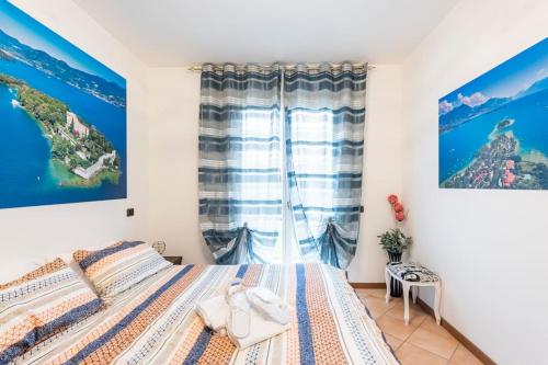a bedroom with a bed and a window at Limone Apartment - Featuring a Private Garden and Access to a Pool in Barcuzzi