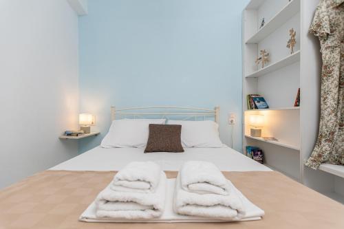 a bedroom with a bed with towels on it at Optasia - Naxos Center Cozy House in Naxos Chora