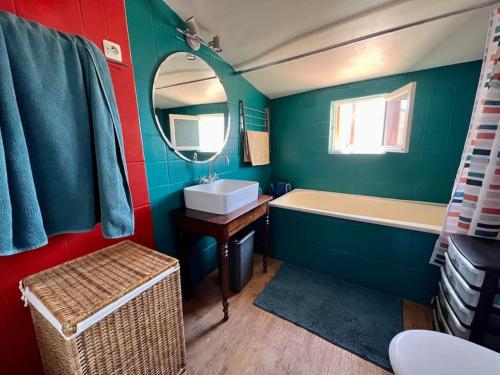 a bathroom with a sink and a tub and a mirror at Une ambiance bohème sur les toits de Sainte-Anne in Montpellier