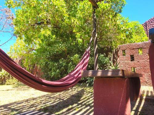 a hammock hanging from a tree in a yard at Cabañas Giramundos in Punta Del Diablo