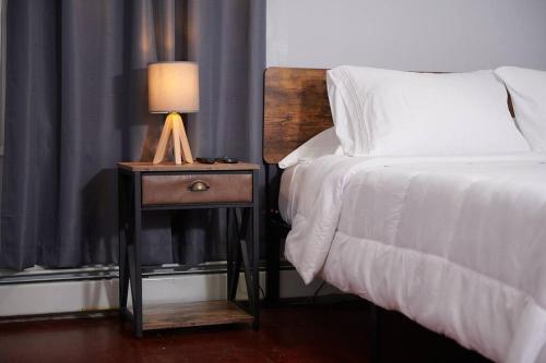 a bed with a lamp on a nightstand next to a bed at Cozy apartment 2nd 10min Walk Downtown and City View in Providence