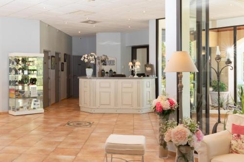 a room with a flower shop with a couch and flowers at Hôtel La Bastide Saint Martin in Carcassonne