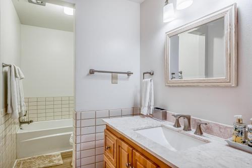 uma casa de banho com um lavatório, um espelho e uma banheira em 20 S Angel Fire Rd #103 em Angel Fire