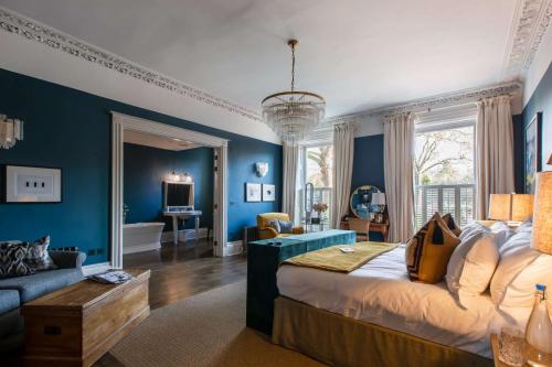 a bedroom with blue walls and a bed and a couch at No38 The Park in Cheltenham