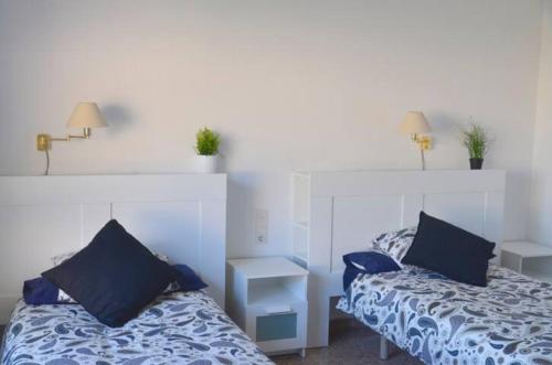 a bedroom with two beds with blue pillows at Villa Montgrau in Llano de Gorra