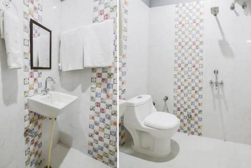 a white bathroom with a toilet and a sink at Corbett Wildlife Homestay in Rāmnagar