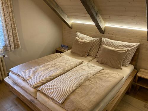 1 cama grande con almohadas en la habitación en Horské apartmány Rejvíz - Borůvka a Brusinka, en Rejvíz