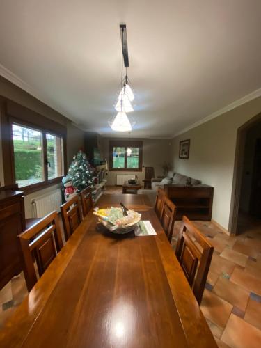 a dining room with a table and a christmas tree at A couquiña in Ponteareas
